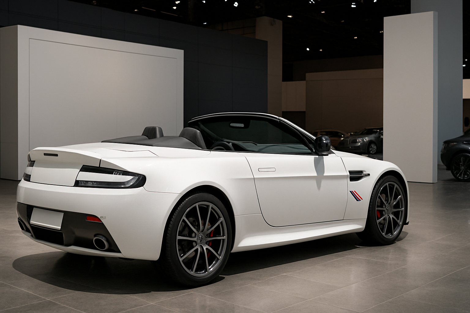 Low, white convertible sports car with dark wheels and red brake calipers on a glossy showroom floor under soft lighting
