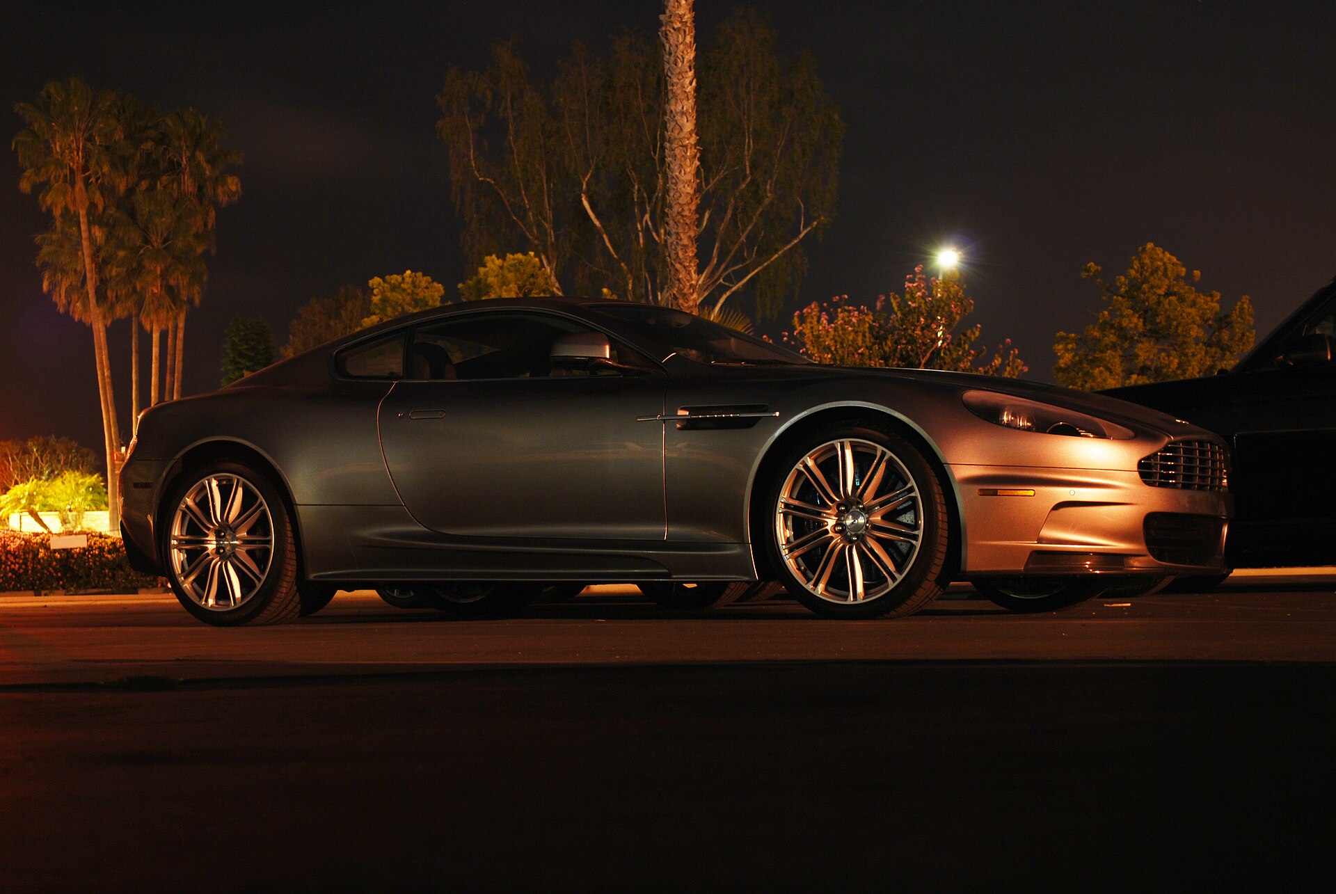 Aston Martin DBS V12 (2007–2012) in silver, front three-quarter view.