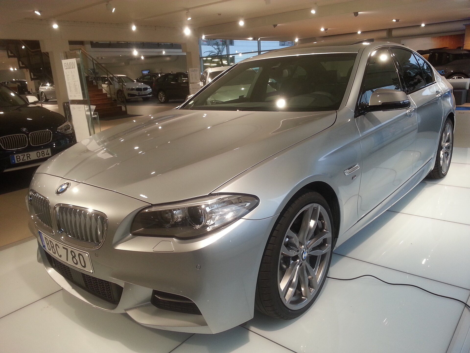 BMW M550d xDrive F10 sedan parked on the street